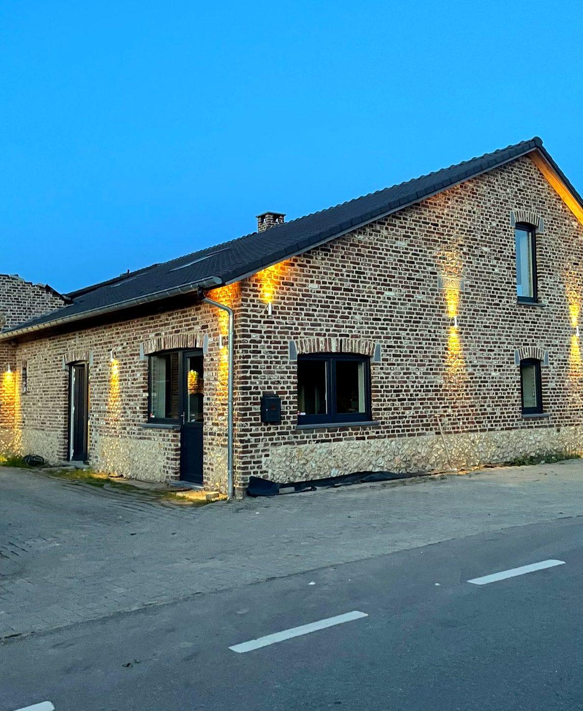 De gevel van Maison Campagnard in Teuven bij avondlicht, gerenoveerde vakantiewoning in de Voerstreek